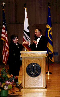[Photo of 
Chancellor Greenwood, receiving a baton from Arts Dean Edward Houghton
during Thursday's dedication ceremony for the new Music Center.]