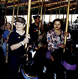 [Photo of Chancellor Greenwood riding the Boardwalk carousel]