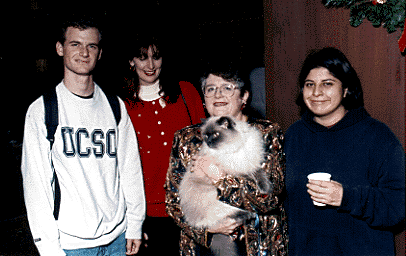 [Picture Chancellor Greenwood, one of her cats, and
guests at the holiday party]