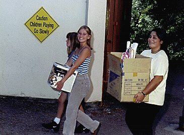 [Photo of students carrying boxes of stuff]