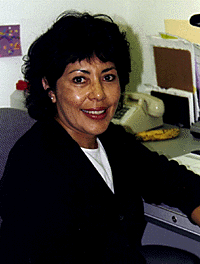 [Photo of Olga Najera-Ramirez at her desk]