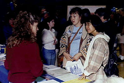 [Photo of prospective student and family at Scholars Day information table]