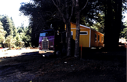 [Photo of modular house on semi truck]