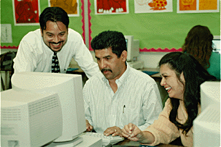 [Photo of East Side parents with Ed Aguilar at the computer]