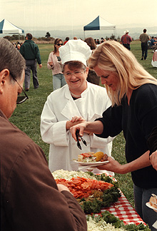 [Photo of Chancellor Greenwood at food table]