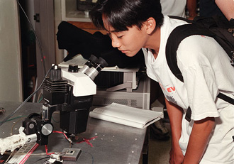 [Photo of student with microscope]